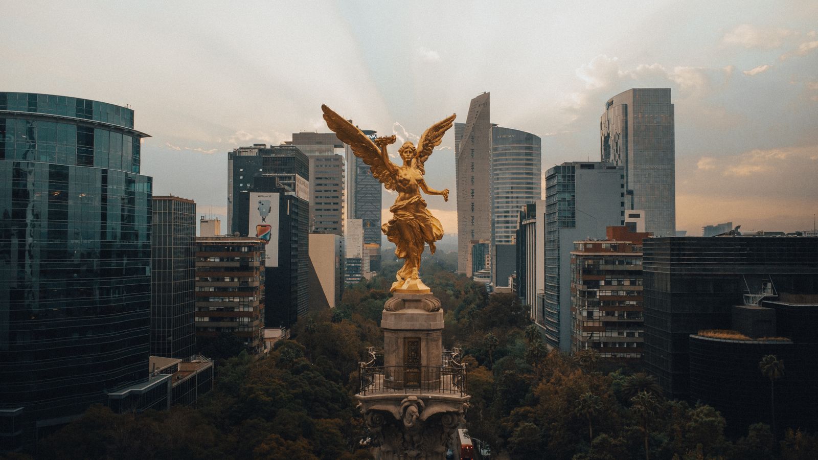 Ángel de la Independencia with the Mexico City skyline at dusk